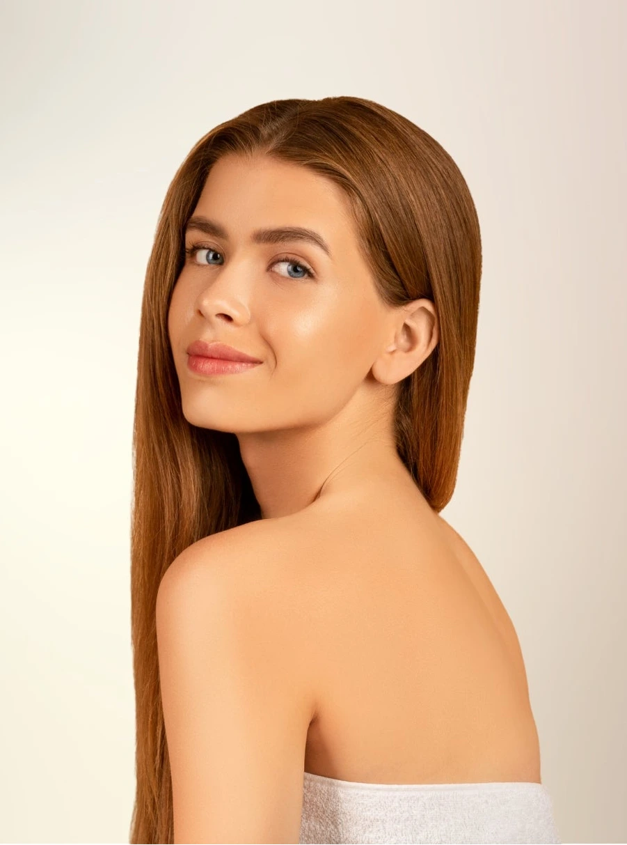 Woman with long brown hair on a plain background