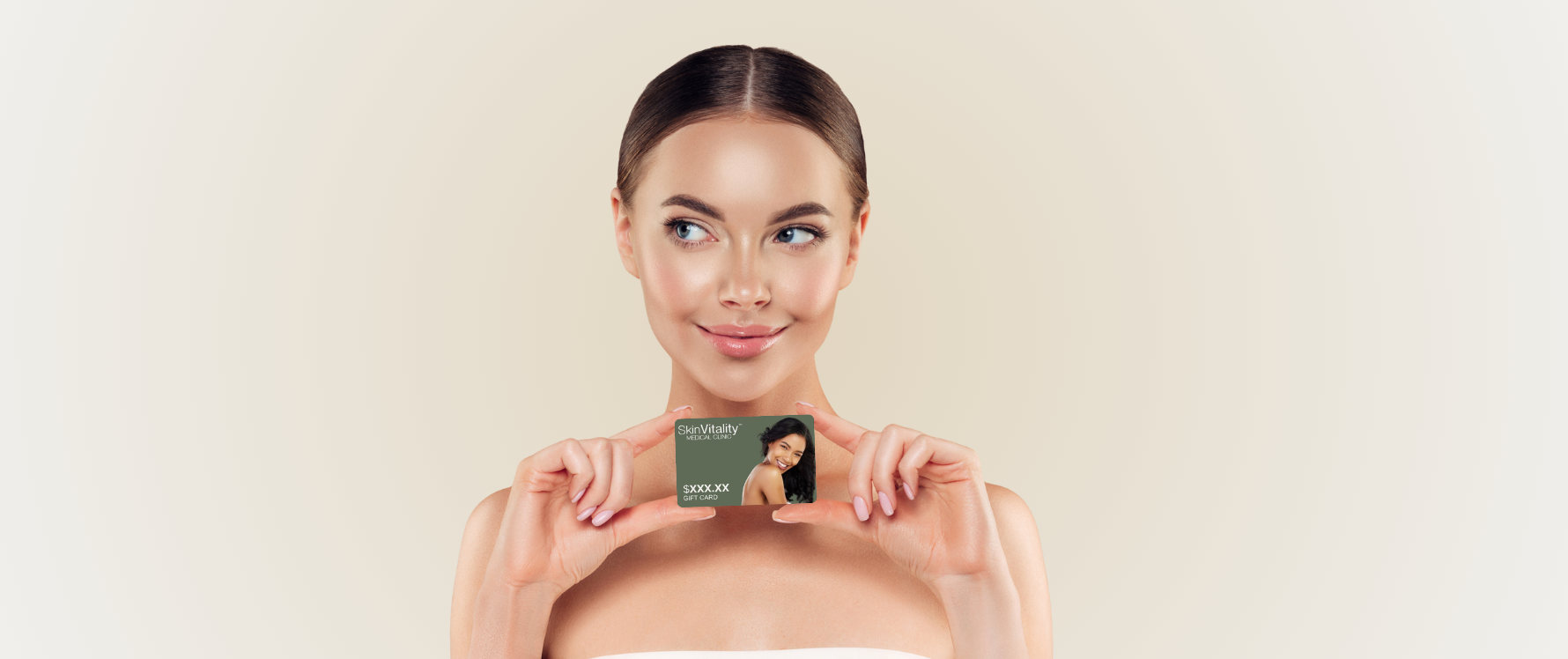 Woman holding a skincare product box against a beige background
